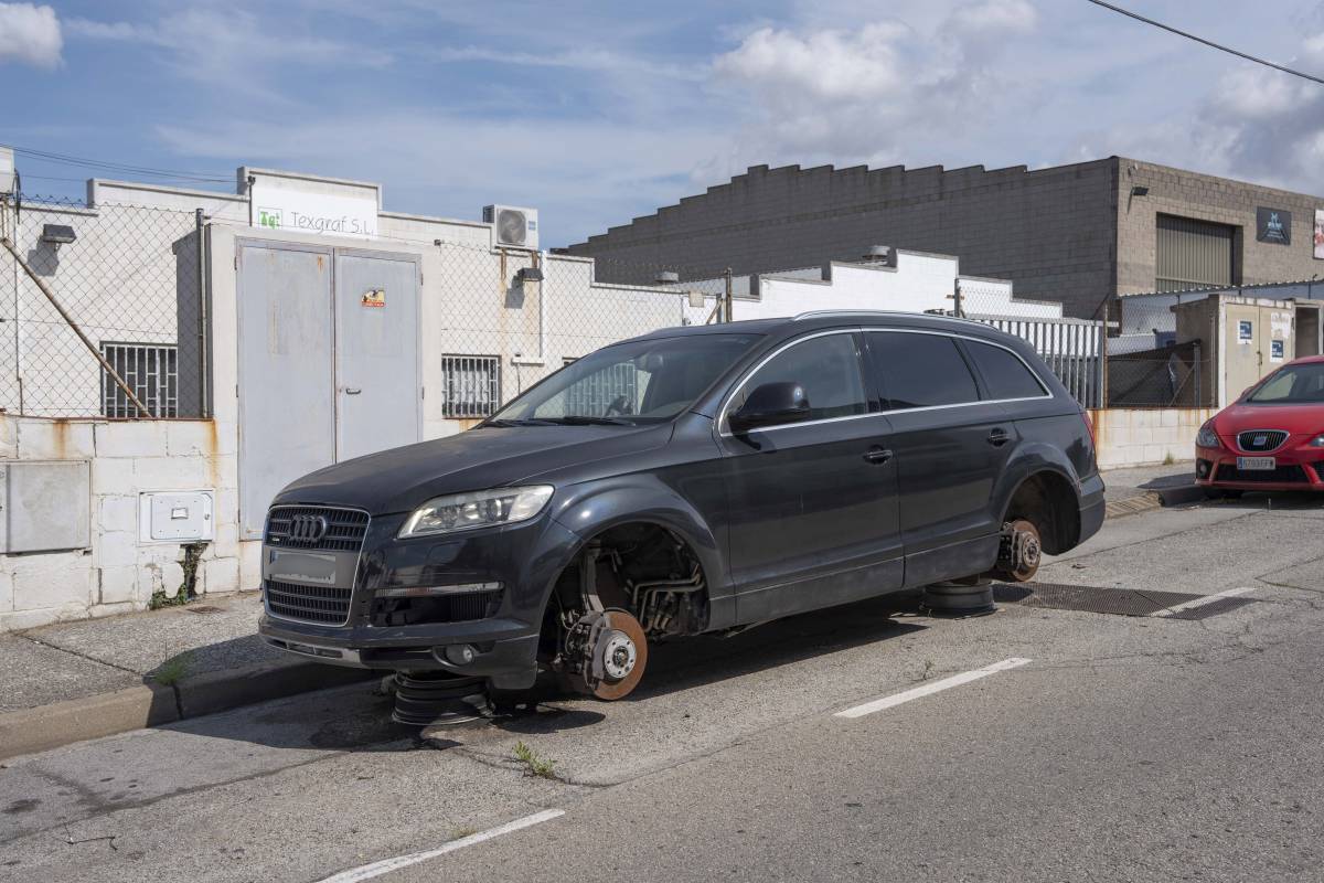 Un vehicle abandonat amb els pneumàtics i les llantes robades, a Can Parellada, al costat del polígon de Colom II - Alberto Tallón