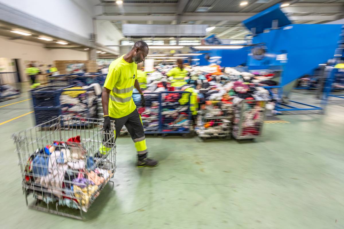 Treballadors de Formació i Treball en el procès de selecció i preparació de roba - JUANMA PELÁEZ Treballadors de Formació i Treball en el procès de selecció i preparació de roba