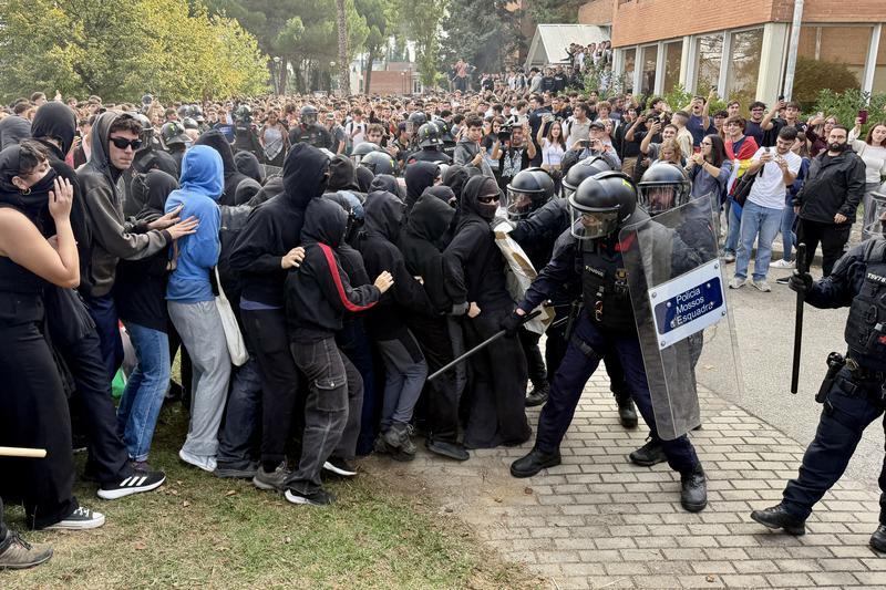 Antiavalots dels Mossos donen cops de porra per separar dos bàndols enfrontats a la UAB. - Antiavalots dels Mossos donen cops de porra per separar dos bàndols enfrontats a la UAB.